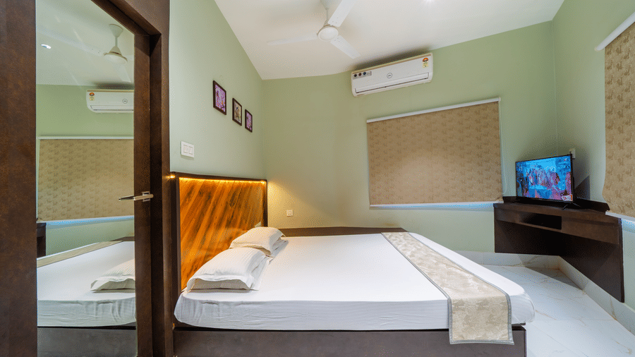 Bedroom with a double bed, a wooden headboard, a TV, and an A/C – Hotel Dolphin Puri