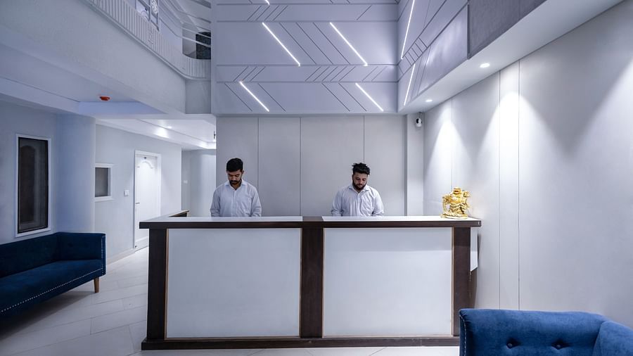 front view shot of the reception desk at Hotel Downtown17, Chandigarh with two staff members standing behind the desk