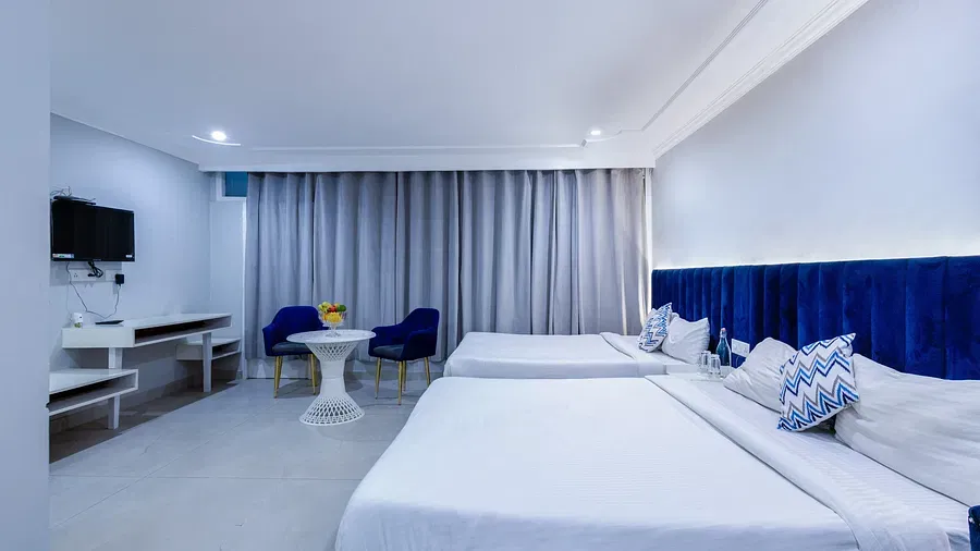 Family Room featuring two large beds with white linens and blue accents. - Hotel Downtown17, Chandigarh