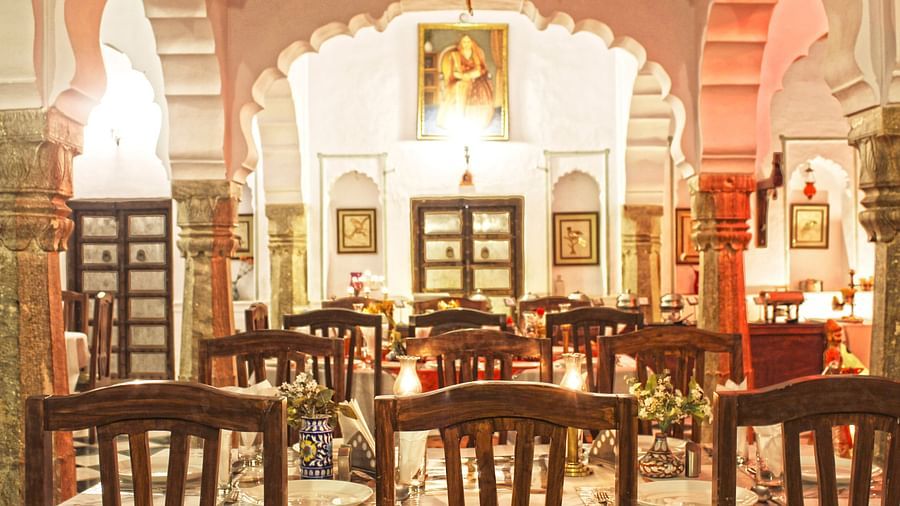 A beautifully set dining room at Fort Barli, featuring ornate arches and warm lighting.