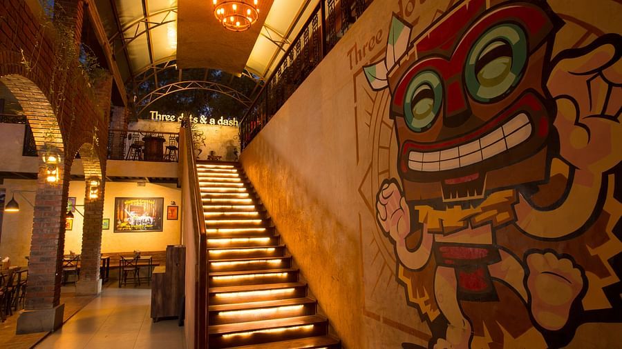 a staircase leading upstairs with graffiti on the wall beside the staircase - Hotel Fountain Tree By TGI - JP Nagar, Bangalore