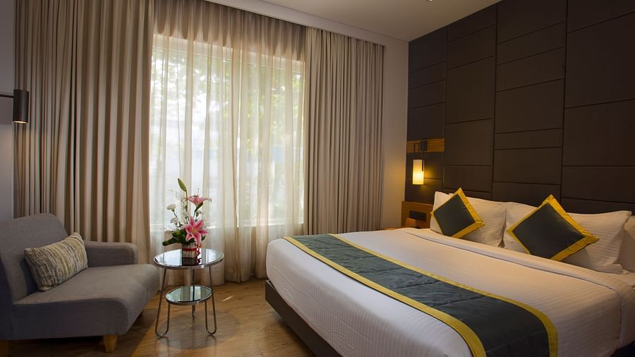 view of a bedroom with a large bed and a small table and sofa - Hotel Fountain Tree By TGI - JP Nagar, Bangalore