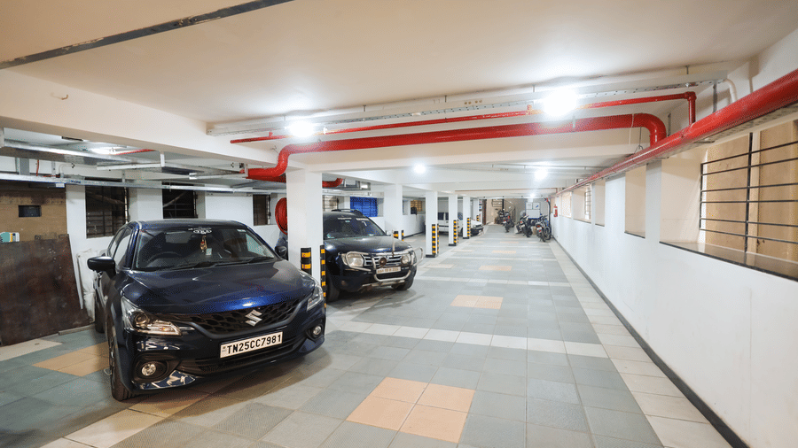 Covered free onsite parking garage area with cars parked at Hotel Grand Sabarees Madurai.