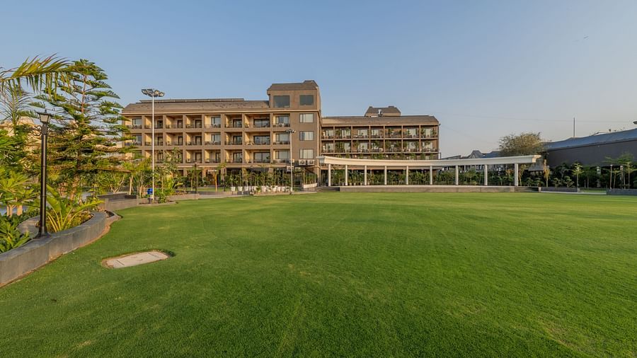 Lawn area at Hotel Highway King, Bagru, with a view of the main building and surrounding landscape elements.