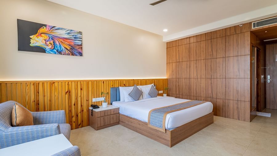 Club room with double bed, lounge chairs, and ceiling fan at Hotel Highway King, Bagru