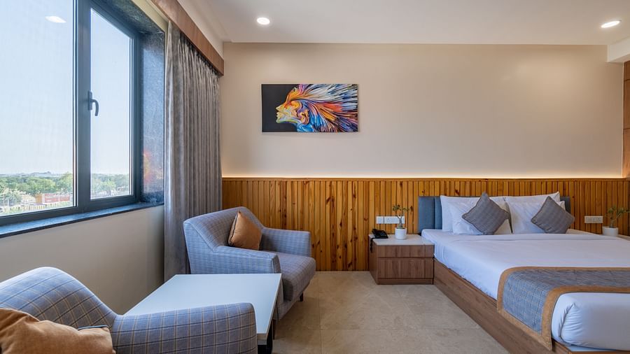 Club room with a double bed, lounge chairs and a large window at Hotel Highway King, Bagru
