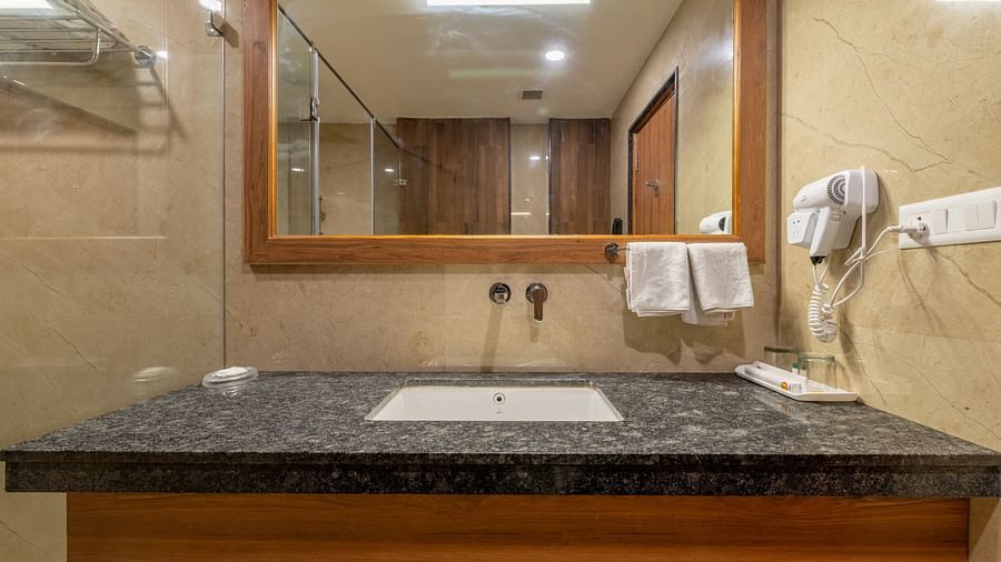 A bathroom in club room with black granite countertop at Hotel Highway King, Bagru