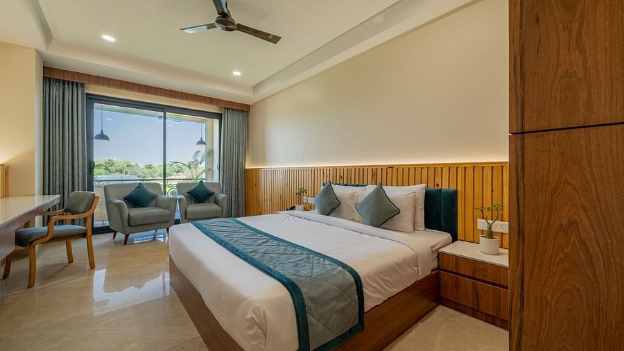 An executive king room with lounge chairs and natural light near the window at Hotel Highway King, Bagru.