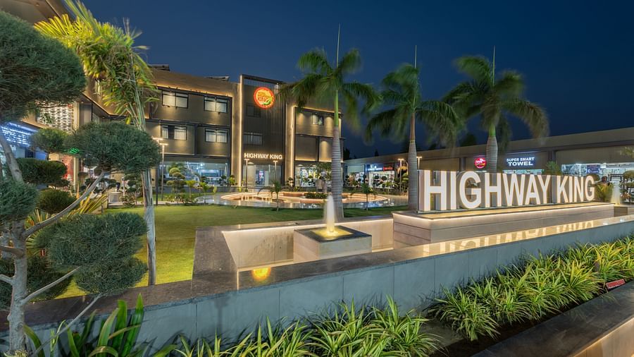 Exterior of Hotel Highway King, Behror, along with the well-manicured lawn and a signage with 'Highway King' written out on an elevated platform.