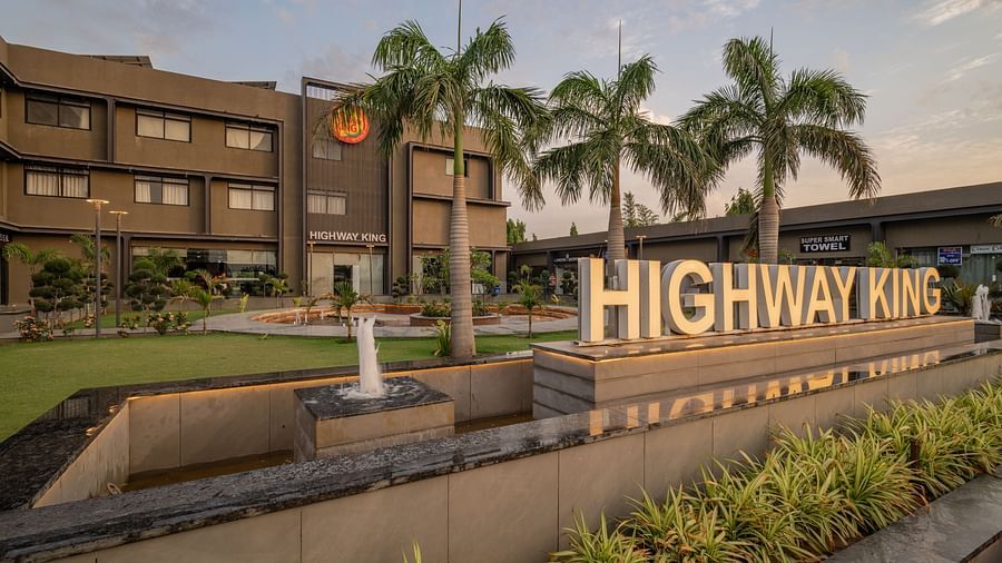 Exterior of Hotel Highway King, Behror, along with the well-manicured lawn and a signage with 'Highway King' written out on an elevated platform.
