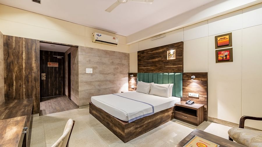 Extended view of the Maharaja Deluxe Room at Hotel Highway King, Behror, furnished with a double bed, air-conditioning, a work desk and seating area for two.