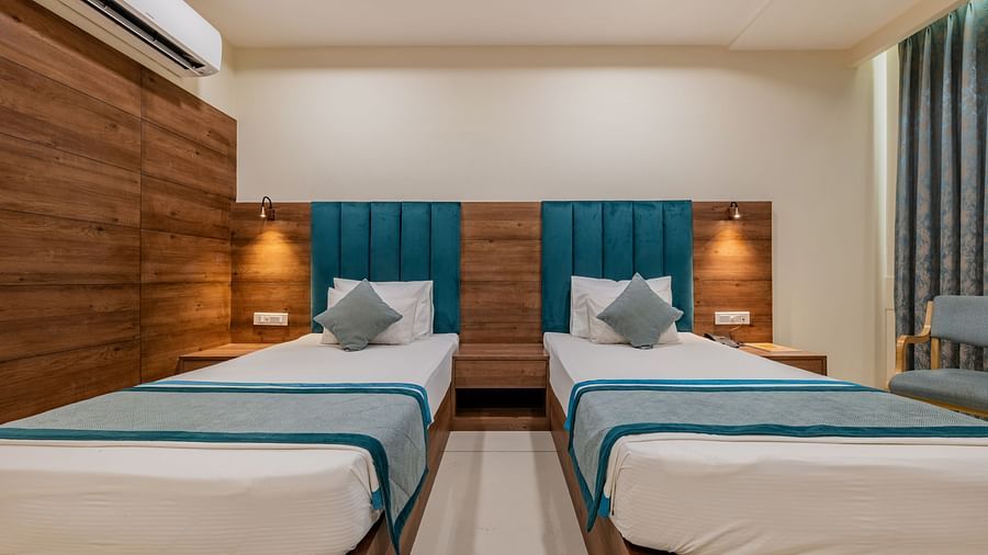 King Twin Bed Room with two single beds, wood-panelled walls, and soft lighting at Hotel Highway King, Bilaspur.