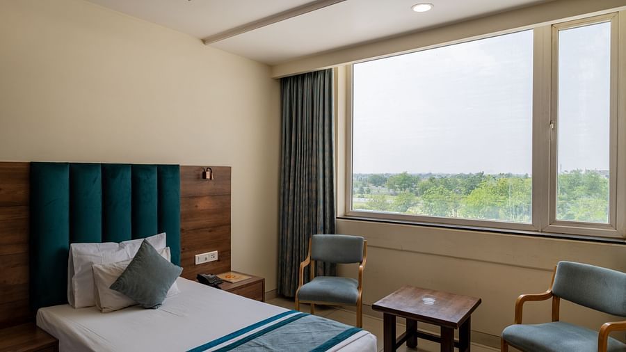 Lounge seating by the window with natural light in a King Twin bed Room at Hotel Highway King, Bilaspur.