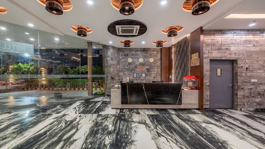 Reception area with black marble desk and contemporary decor at Hotel Highway King, Bilaspur.