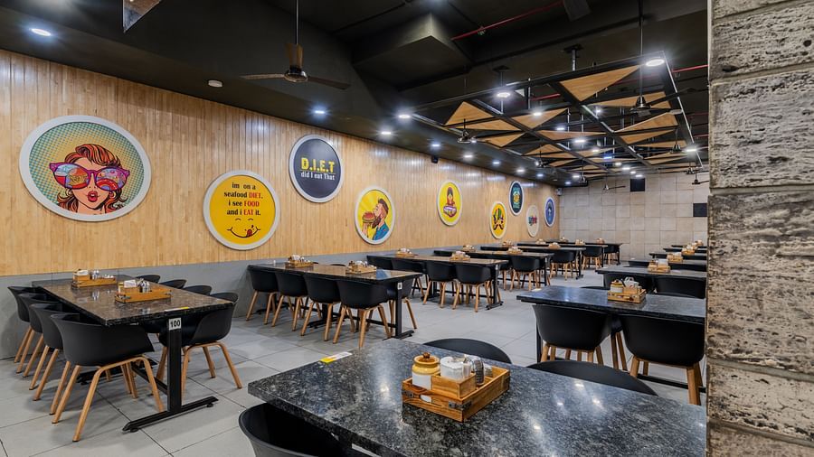 Restaurant view with playful wall illustrations and a clean, organised dining area at Hotel Highway King, Bilaspur.