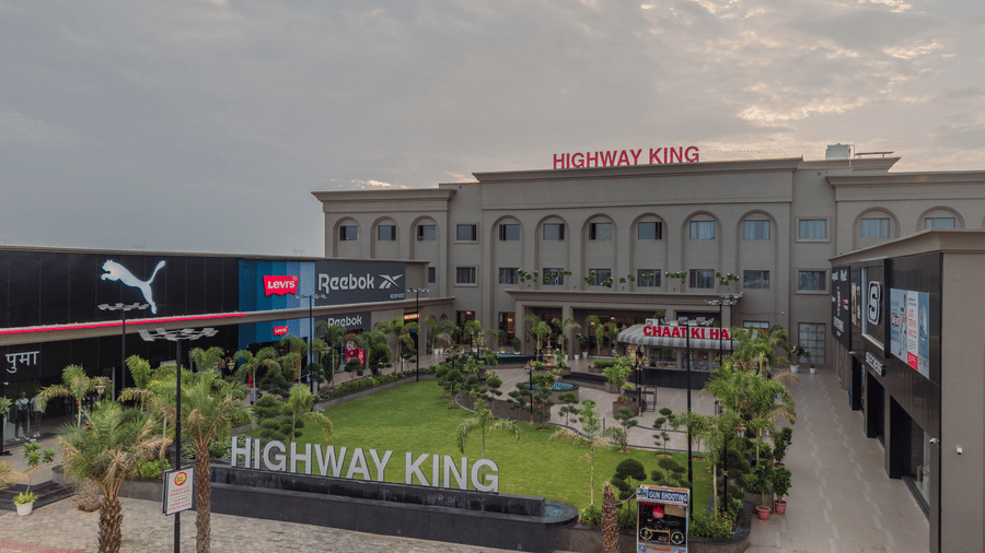 Multi-storey building with landscaped grounds and surrounding commercial spaces.