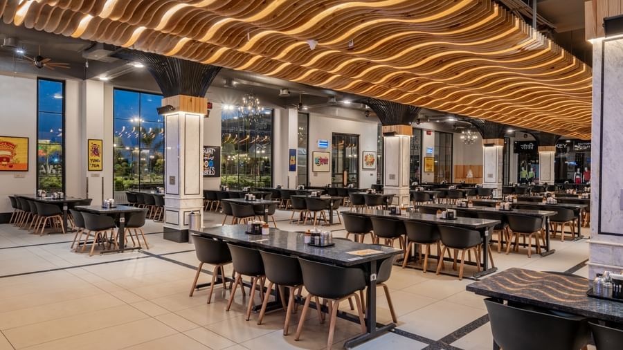 Dining area at Hotel Highway King, Kishangarh, highlighting the contemporary lighting and table setup.