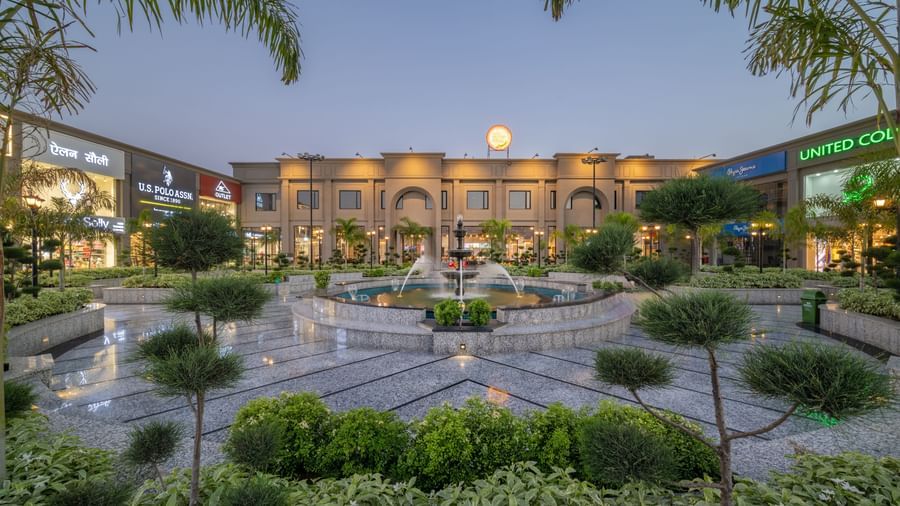 Garden and courtyard view of Hotel Highway King, Kishangarh with fountain, greenery and building in the background.