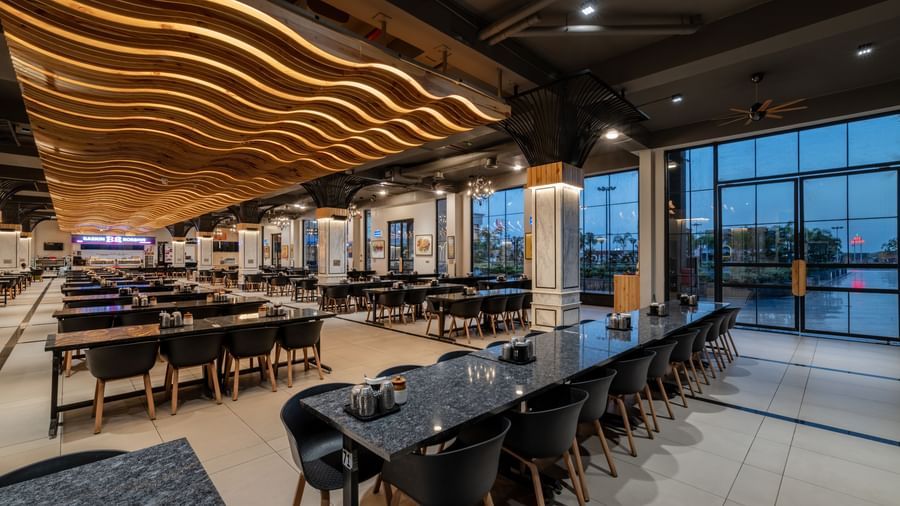 Restaurant section with long dining tables and overhead lighting at Hotel Highway King, Kishangarh.