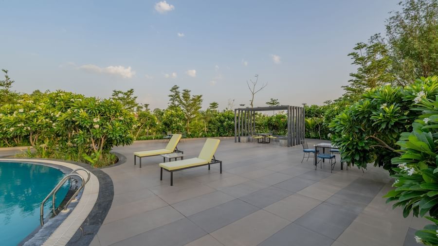 A wide view of the crystal-clear swimming pool and its surrounds at Hotel Highway King Shahpura.