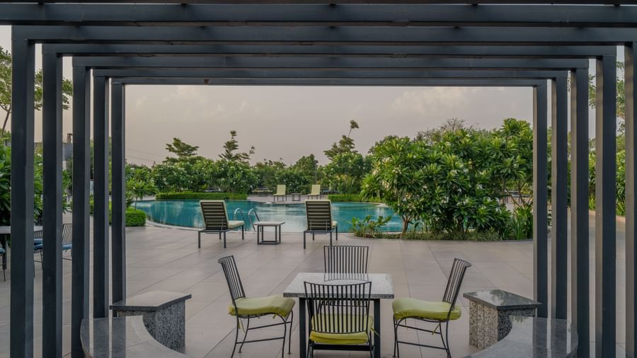 Another view of the open-air dining or lounge space under a pergola at Hotel Highway King Shahpura.