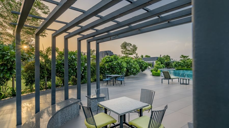A modern outdoor dining or lounge area with a pergola at Hotel Highway King Shahpura.