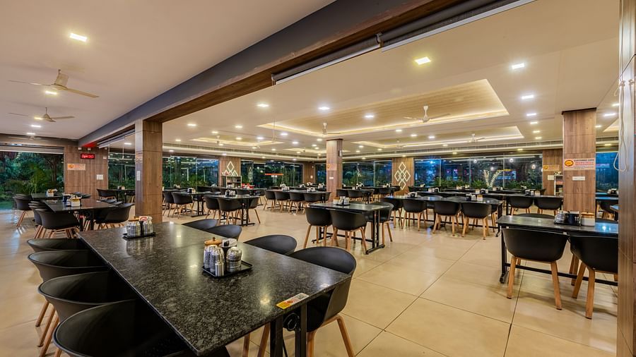 A perspective view of the neatly set dining area at Hotel Highway King Shahpura, awaiting diners.
