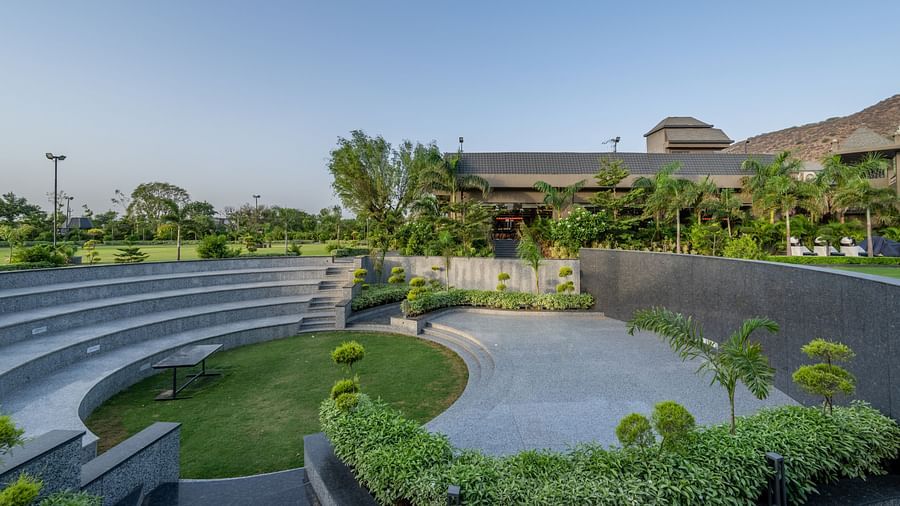 An outdoor amphitheater or tiered seating area with a central green space at Hotel Highway King Shahpura.