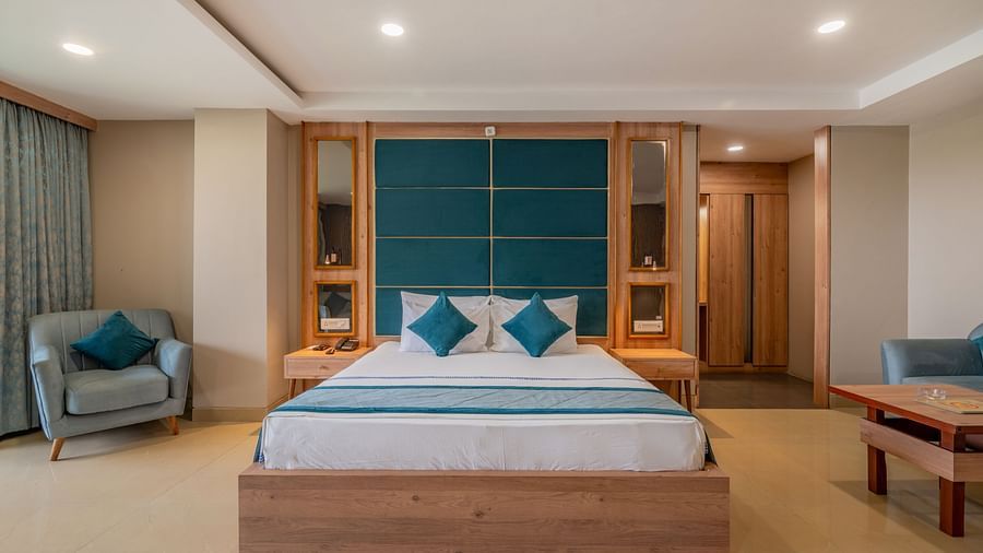 A inviting guest room at Hotel Highway King Shahpura featuring a bed, seating, and ample lighting.