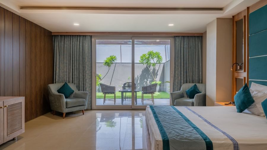 A wide view of a suite at Hotel Highway King Shahpura, including a bedroom and sitting area with outdoor access
