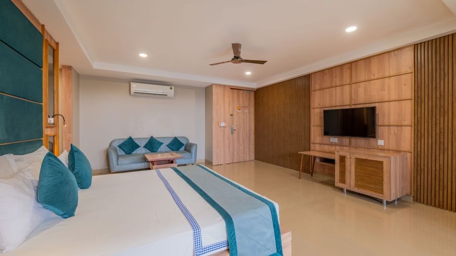 A close-up of a guest room at Hotel Highway King Shahpura highlighting the bed and a portion of the seating.