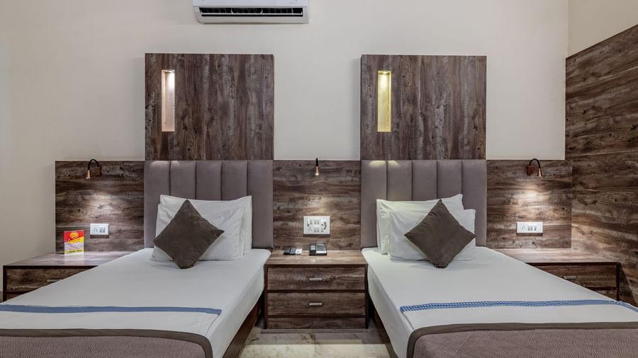 A twin room at Hotel Highway King Shahpura featuring two comfortable beds and modern decor.