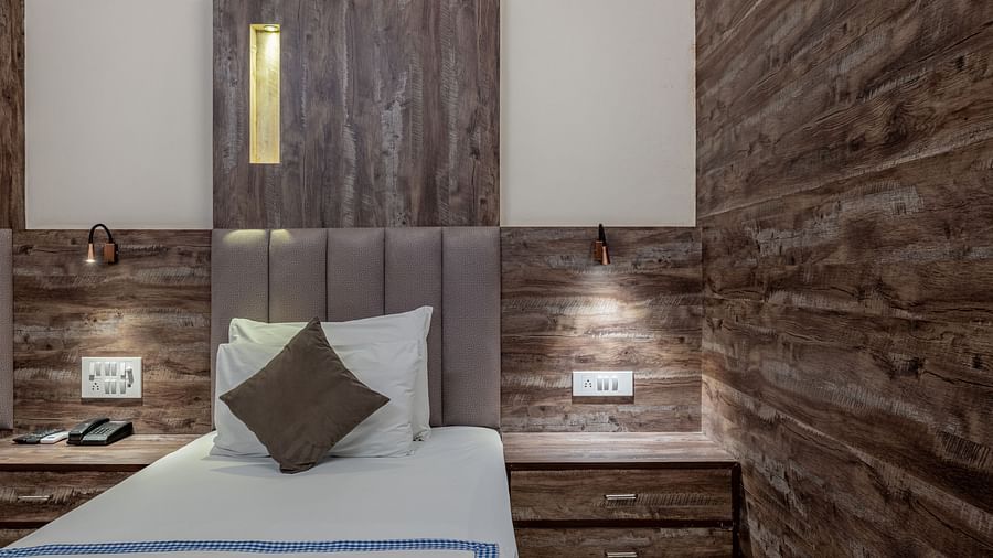 A cosy bedroom in Hotel Highway King Shahpura featuring a neatly made bed and bedside lamps.