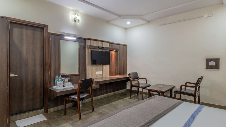 A standard guest room at Hotel Highway King Shahpura with a  bed and wooden furnishings.