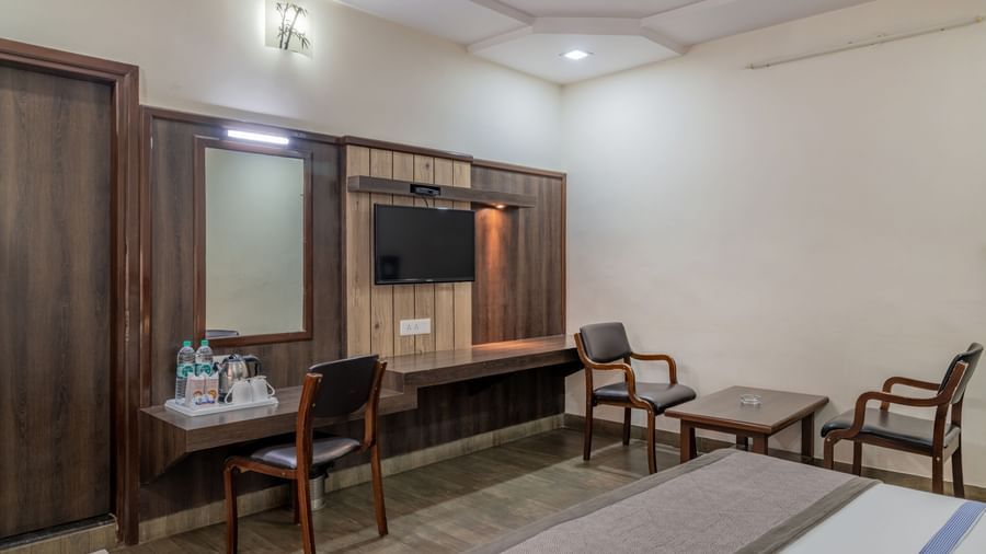 A simply furnished room with a double bed and lighting fixtures above at Hotel Highway King Shahpura.
