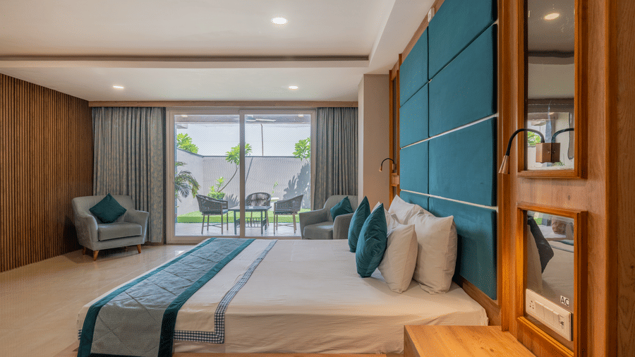 A well-appointed guest room with a large bed and a view of the outside area at Hotel Highway King Shahpura.