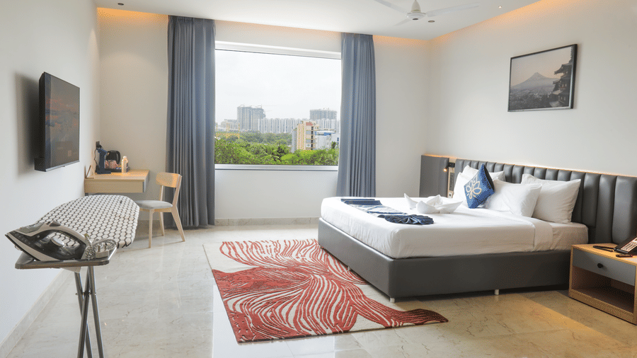 Spacious Luxury Suite bedroom with king bed and blue drapes at Hotel Kyzen HiTech City – Your Zenly Stay.