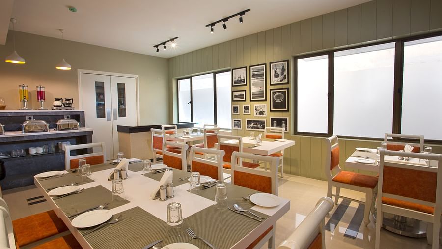 A contemporary dining area with set tables, modern lighting and black and white wall photographs  - Hotel Langford Keys by TGI, Shanti Nagar