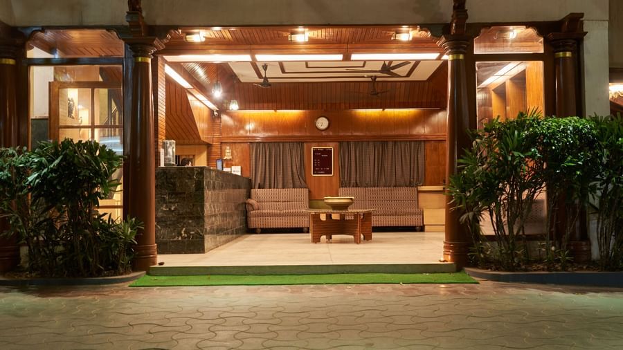 The main entrance of Hotel Mamallaa Heritage illuminated at night, inviting guests into the warmly lit interior with traditional architectural details.