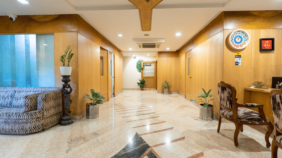 The welcoming lobby and reception area at Hotel Pai Comforts, JP Nagar, featuring polished marble flooring.