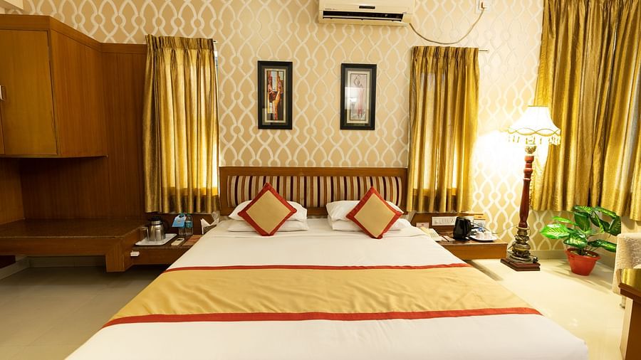 A double bed with side table and a lamp inside one of the rooms - Hotel Pai Vista, KR Road
