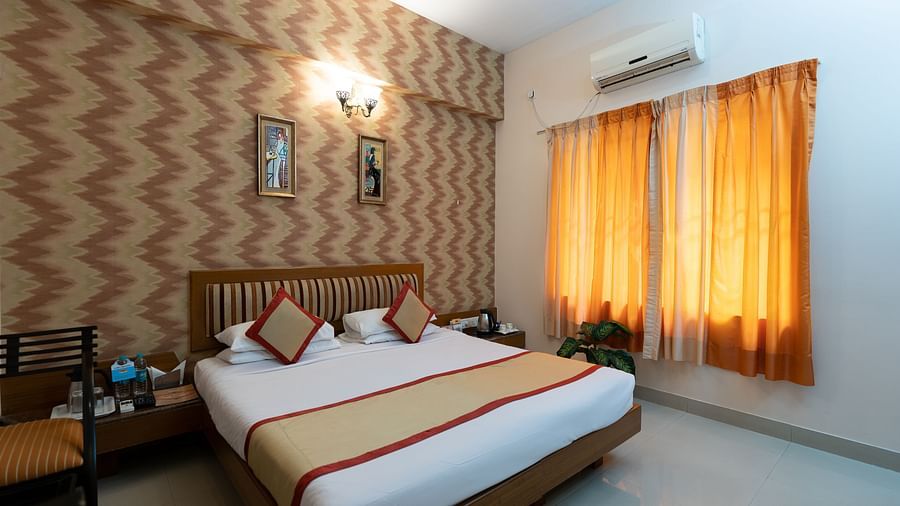A double bed with side tables inside one of the rooms - Hotel Pai Vista, KR Road