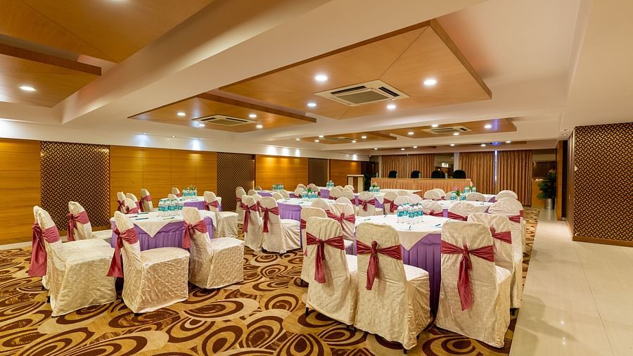 round table seating inside the banquet hall during an event - Hotel Pai Vista, Mysore
