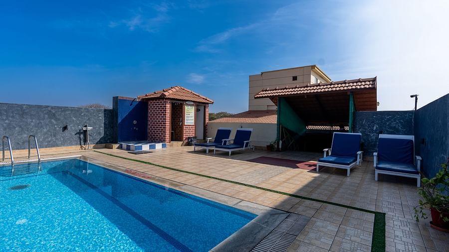 overview of the swimming pool with loungers kept on the side - Hotel Pai Vista, Mysore