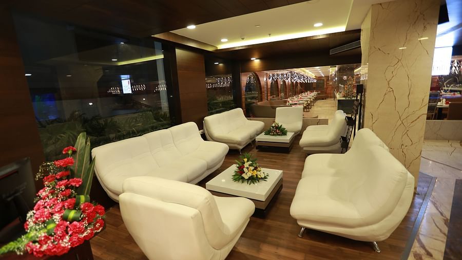 a living area with multiple sofas and chairs to sit - Hotel Park Elanza, Chennai