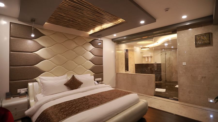 a bedroom with a large bed and washroom visible from the bedroom - Hotel Park Elanza, Chennai
