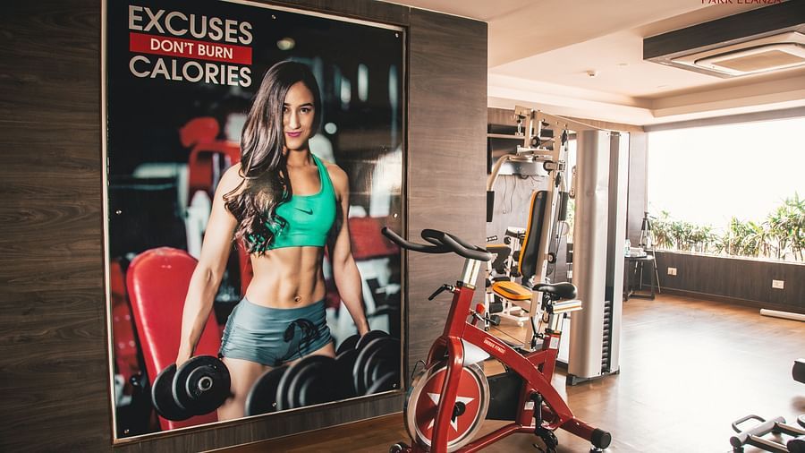 inside of a gym with a poster on the wall and gym equipment placed beside the wall - Hotel Park Elanza, Chennai
