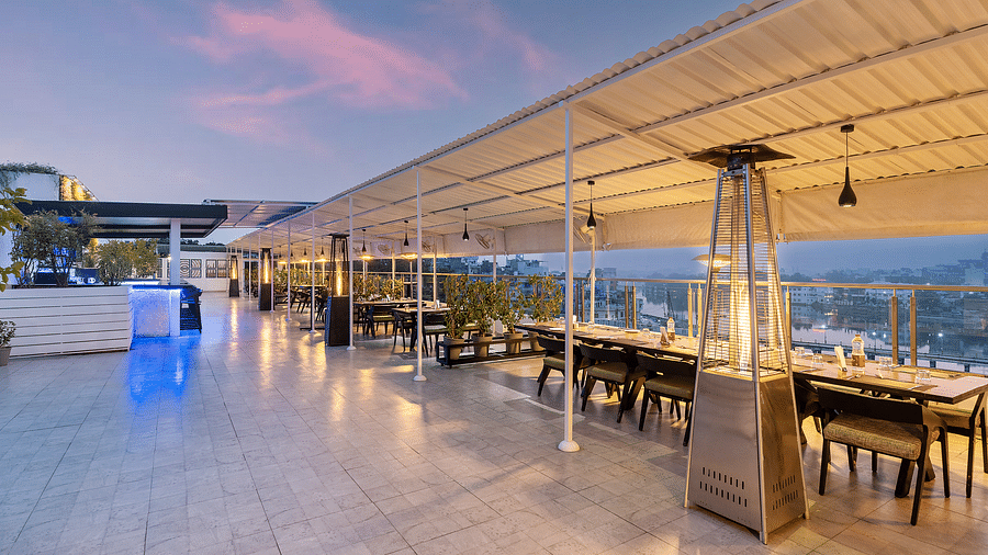 A wide angle shot of our rooftop restaurant in Udaipur with a backdrop of clear sky - Hotel Rajdarshan, Udaipur.