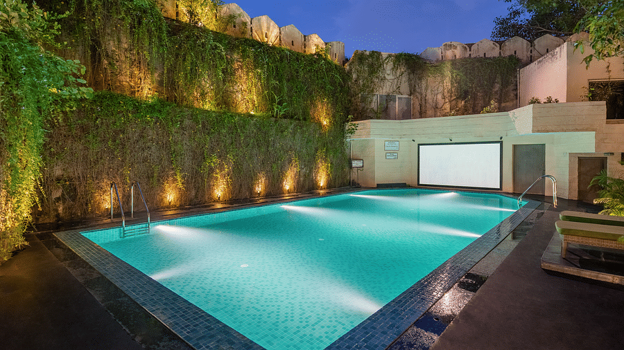 Shot of the swimming pool at the hotel in the evening with well lit surroundings - Hotel Rajdarshan, Udaipur.
