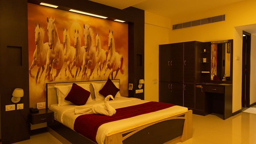 a bedroom with a large bed and a wardrobe on the side of the room - Hotel Rockfort View, Trichy
